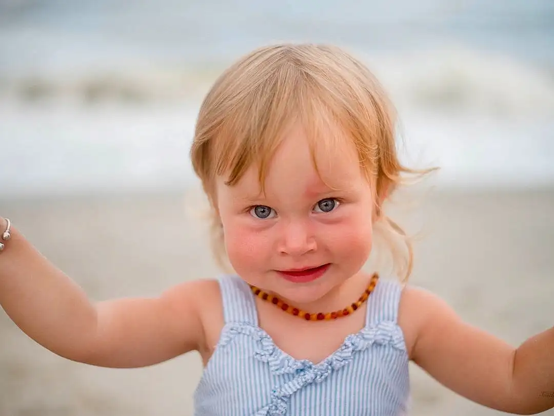 Nose, Cheek, Skin, Lip, Smile, Facial Expression, Happy, Sleeve, Flash Photography, Baby & Toddler Clothing, Gesture, Toddler, Fun, People In Nature, Child, Beach, Baby, Jewellery, Thumb, Leisure, Person, Joy
