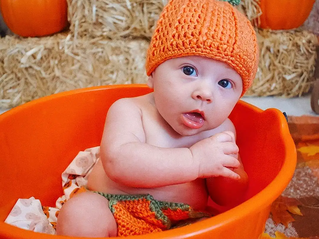 Orange, Pumpkin, Baby, Plant, Toddler, Baby & Toddler Clothing, Cap, Calabaza, Child, Natural Foods, Gourd, Cucurbita, Sitting, Winter Squash, Vegetable, Wood, Baby Products, Peach, Person, Surprise, Headwear