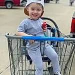 Photograph, Shopping Cart, Smile, White, Tire, Vehicle, Wheel, Car, Toddler, Leisure, Electric Blue, Human Leg, Child, Fun, Hat, Recreation, Cart, T-shirt, City, Person, Joy, Headwear