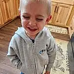 Clothing, Face, Nose, Hair, Cheek, Skin, Head, Smile, Hairstyle, Eyes, Wood, Cabinetry, Sleeve, Baby & Toddler Clothing, Standing, Happy, Toddler, Person, Joy