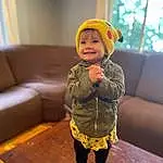 Face, Skin, Head, Outerwear, Facial Expression, Smile, Couch, Sleeve, Standing, Baby & Toddler Clothing, Window, Toddler, Wood, Comfort, Cap, Happy, Fun, Child, Person, Joy