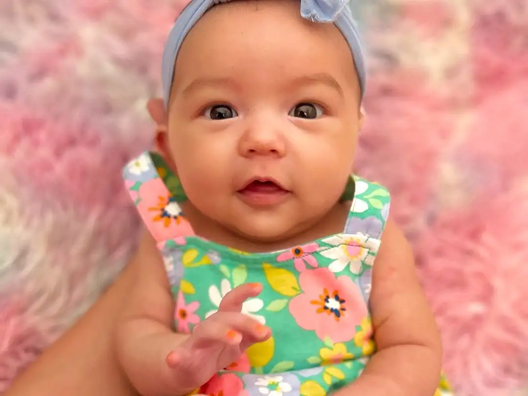 Face, Cheek, Skin, Head, Lip, Chin, Eyes, Dress, Baby & Toddler Clothing, Human Body, Neck, Textile, Baby, Iris, Happy, Finger, Pink, Fawn, Toddler, Person