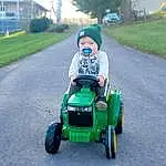 Tire, Wheel, Plant, Riding Toy, Automotive Tire, Tractor, Vroom Vroom, Vehicle, Asphalt, Automotive Design, Grass, Tree, Rolling, Automotive Wheel System, Toddler, Auto Part, Road, Lawn, Agricultural Machinery, Grassland, Person, Headwear