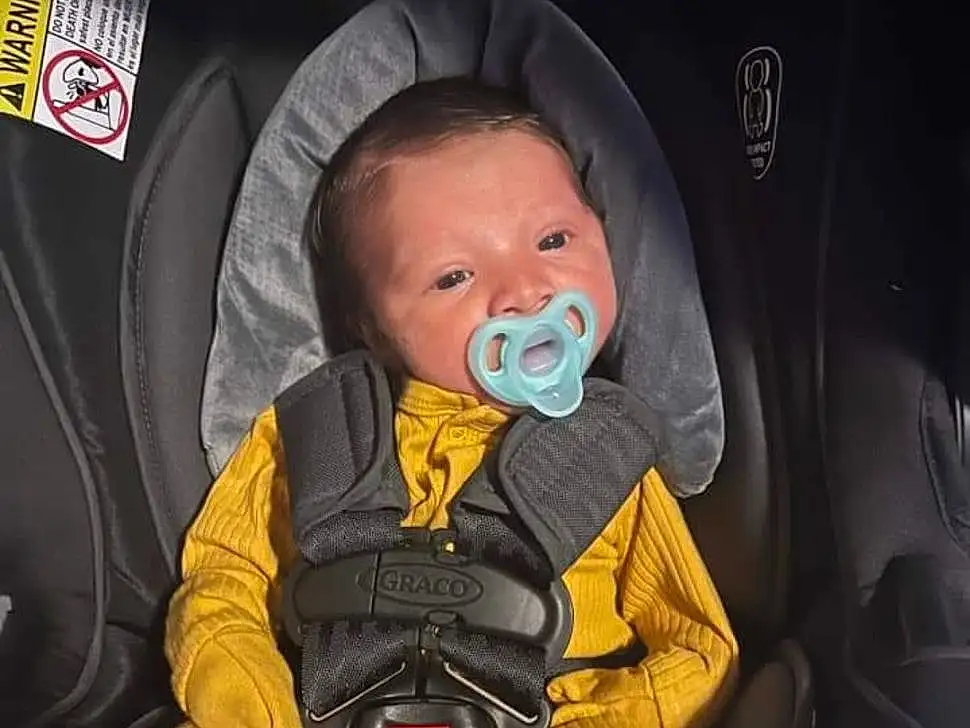 Outerwear, Facial Expression, Comfort, Baby Carriage, Car Seat, Baby, Toddler, Vroom Vroom, Baby In Car Seat, Baby & Toddler Clothing, Child, Personal Protective Equipment, Font, Photo Caption, Baby Products, Auto Part, Sitting, Screenshot, Person