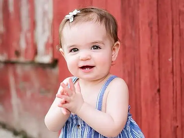 Face, Skin, Head, Smile, Eyes, Facial Expression, Baby & Toddler Clothing, Sleeve, Flash Photography, One-piece Garment, Happy, Standing, Pink, Iris, Toddler, Day Dress, Pattern, Grass, Child, Baby, Person, Joy