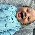 Nose, Cheek, Skin, Lip, Smile, Eyebrow, Facial Expression, Mouth, Baby & Toddler Clothing, Sleeve, Textile, Baby, Iris, Happy, Baby Laughing, Toddler, Comfort, Child, Linens, Person