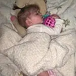 Cheek, Skin, Head, Comfort, Leg, Sleeve, Textile, Baby & Toddler Clothing, Gesture, Pink, Headgear, Baby, Baby Sleeping, Toddler, Child, Linens, Pattern, Bedtime, Nap, Sitting, Person