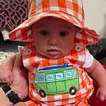 Skin, Cap, Orange, Baby, Hat, Yellow, Pink, Finger, Headgear, Sun Hat, Toddler, Red, Baby & Toddler Clothing, Baby Carriage, Personal Protective Equipment, Child, Helmet, Plaid, Sitting, Fashion Accessory, Person, Headwear