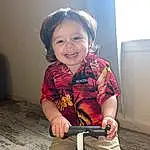 Smile, Wheel, Tire, Photograph, Human Body, Standing, Toddler, Fun, Rolling, Gas, Happy, Riding Toy, Balance, Automotive Wheel System, Human Leg, Electric Blue, Baby & Toddler Clothing, Child, Knee, Sitting, Person, Joy