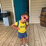 Head, Barrel, Wood, Standing, Waste Container, Shorts, Door, Toddler, Wood Stain, Waste Containment, Hardwood, Happy, Sunglasses, Child, T-shirt, Leisure, Grass, Plank, Fun, Person, Joy