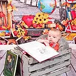 Plant, Orange, Leisure, City, Child, Publication, Event, Book, Market, Toddler, Tree, Toy, Street, Sitting, Room, Recreation, Flower, Marketplace, Person