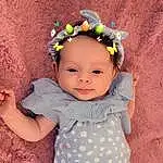 Face, Skin, Arm, Plant, Facial Expression, Flower, Baby & Toddler Clothing, Textile, Sleeve, Iris, Happy, Pink, Smile, Headpiece, Headband, Toddler, Baby, Embellishment, Child, Jewellery, Person, Headwear