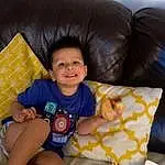 Smile, Couch, Comfort, Shorts, Toddler, Wood, Lap, Fun, Thigh, Happy, Food, Sitting, Child, Thumb, Linens, Living Room, Comfort Food, Finger Food, Ingredient, Person, Joy