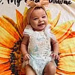 Head, Smile, Eyes, Facial Expression, Leaf, Orange, Plant, Human Body, Baby & Toddler Clothing, Happy, Dress, Toddler, Pumpkin, Calabaza, Couch, Winter Squash, Thigh, Fun, Child, Person, Joy