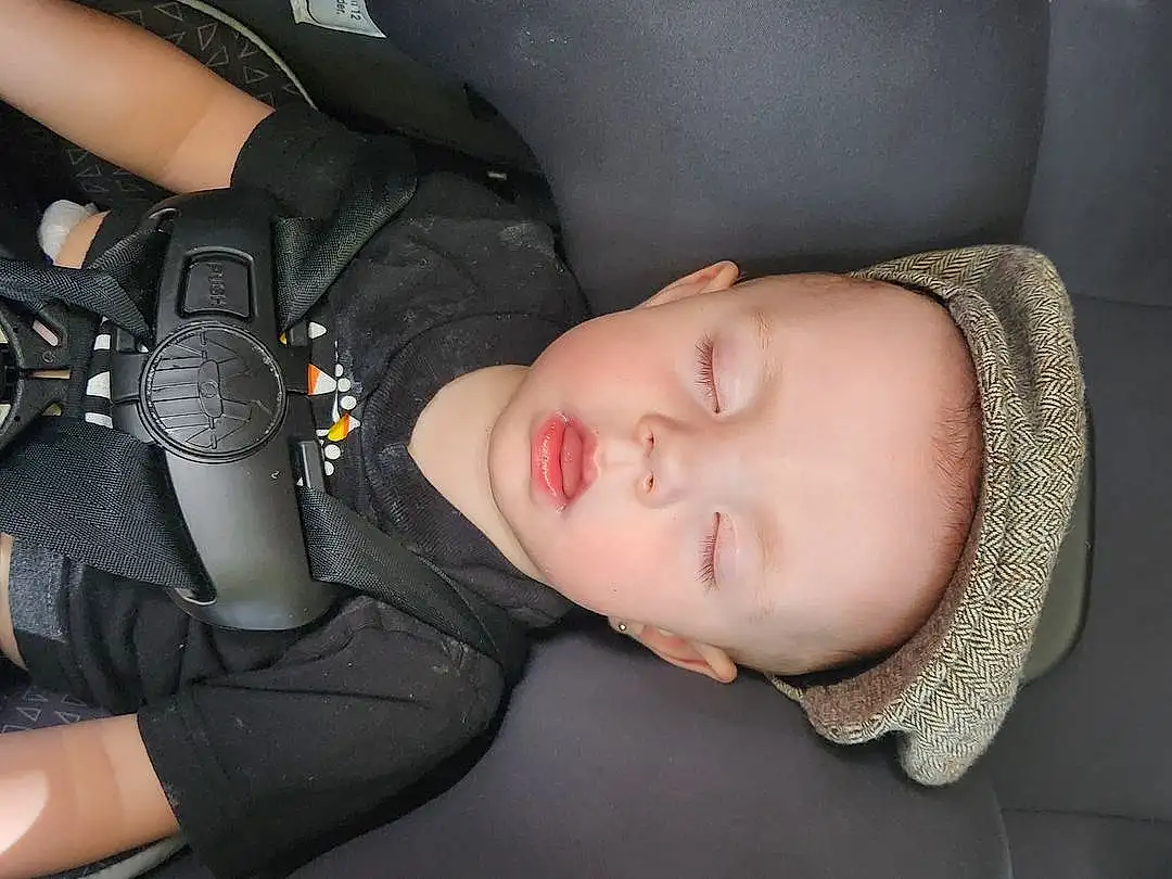 Cheek, Skin, Mouth, Comfort, Flash Photography, Baby, Cool, Toddler, Eyelash, Car Seat, Baby & Toddler Clothing, Auto Part, Vehicle Door, Child, Automotive Design, Baby Products, Steering Wheel, Sitting, Luxury Vehicle, Baby Carriage, Person