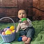 Arm, Baby, Toy, Toddler, Comfort, Wood, Happy, Basket, Storage Basket, Leisure, Easter, Sitting, Event, Child, Fun, Grass, Room, Doll, Wicker, Baby Products, Person