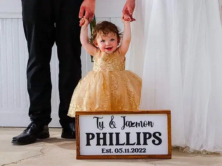 Smile, Dress, Happy, One-piece Garment, Bridal Party Dress, Gesture, Bridal Clothing, Toddler, Gown, Formal Wear, Wedding Ceremony Supply, Event, Fashion Design, Suit, Curtain, Fun, Font, Peach, Child, Person, Joy