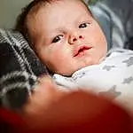 Nose, Cheek, Skin, Lip, Chin, Eyebrow, Comfort, Mouth, Flash Photography, Iris, Baby, Finger, Toddler, Baby & Toddler Clothing, Child, Sitting, Room, Portrait Photography, Eyelash, Linens, Person