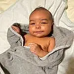 Cheek, Skin, Smile, Lip, Chin, Arm, Comfort, Textile, Sleeve, Iris, Flash Photography, Baby, Happy, Toddler, Linens, Child, Chest, Baby & Toddler Clothing, Abdomen, Sitting, Person