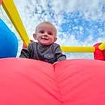 Cloud, Smile, Sky, Blue, Playground, Leisure, Happy, Toddler, Recreation, Chute, Bounce House, Fun, Grass, Outdoor Play Equipment, Electric Blue, Baby, Inflatable, Tree, Comfort, Child, Person, Joy