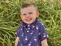 Face, Hair, Head, Smile, Shirt, Hairstyle, Eyes, Plant, People In Nature, Human Body, Sleeve, Happy, Grass, T-shirt, Toddler, Adaptation, Fun, Baby & Toddler Clothing, Leisure, Child, Person, Joy