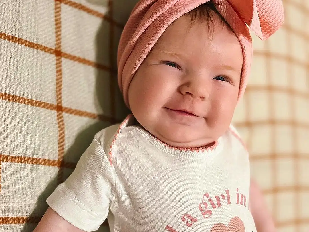 Skin, Smile, Outerwear, White, Baby & Toddler Clothing, Neck, Textile, Sleeve, Baby, Happy, Cap, Pink, Toddler, Cool, Headgear, T-shirt, Pattern, Costume Hat, Beauty, Headpiece, Person, Joy, Headwear