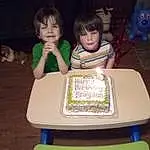 Face, Hair, Head, Table, Furniture, Chair, Sharing, Leisure, Toddler, Fun, Games, Recreation, Indoor Games And Sports, Event, T-shirt, Sitting, Room, Birthday Cake, Child, Dessert, Person, Joy