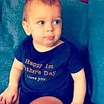 Child, Face, Toddler, Baby, Cheek, Blue, Skin, Head, Chin, Nose, Sitting, Baby & Toddler Clothing, Eyes, Lip, Smile, T-shirt, Leg, Tummy Time, Sleeve, Person