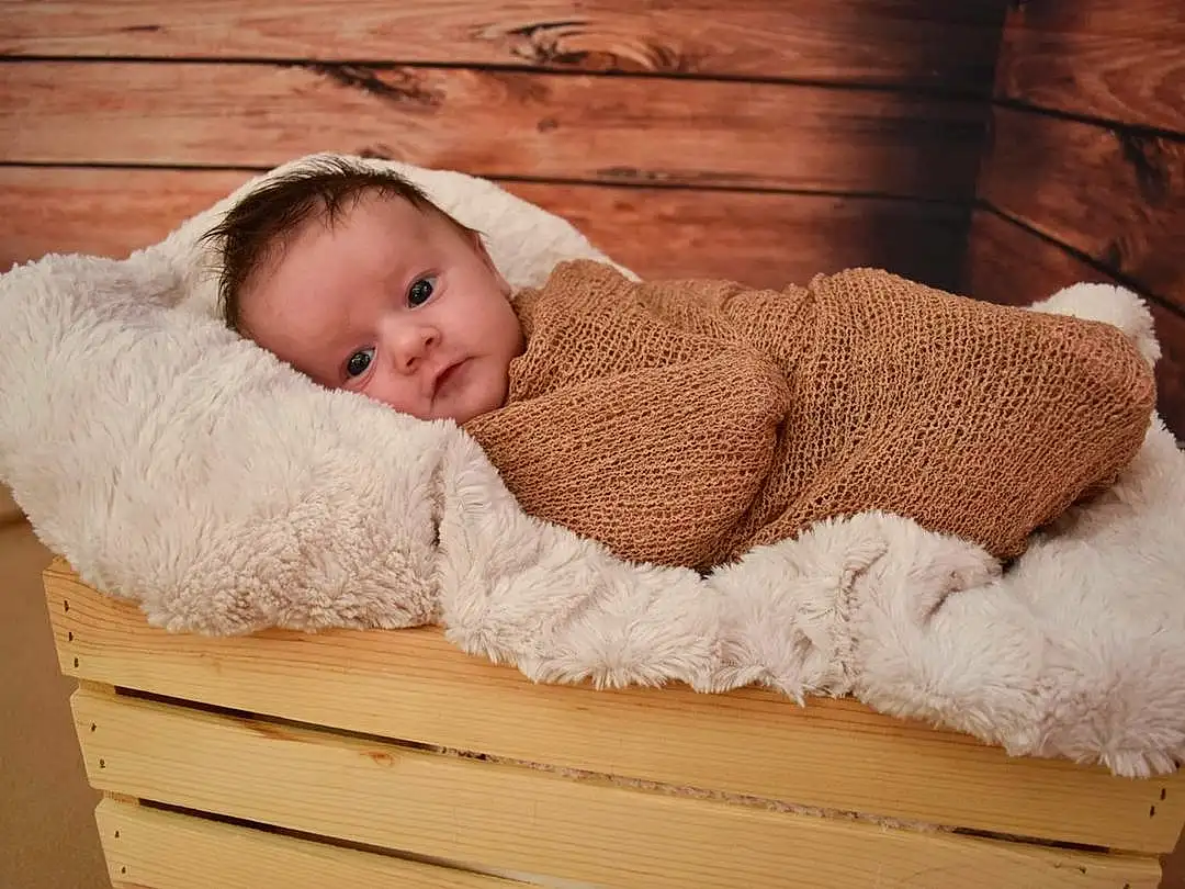 Comfort, Baby & Toddler Clothing, Wood, Baby, Headgear, Toddler, Wool, Baby Sleeping, Child, Sitting, Woolen, Furry friends, Hardwood, Fashion Accessory, Linens, Portrait Photography, Rectangle, Art, Room, Person