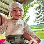 Face, Smile, Skin, Leg, Cap, Plant, Textile, Tree, Sleeve, Hat, Standing, Happy, Baby & Toddler Clothing, Headgear, Finger, Grass, Cool, Toddler, Thigh, Leisure, Person, Joy, Headwear