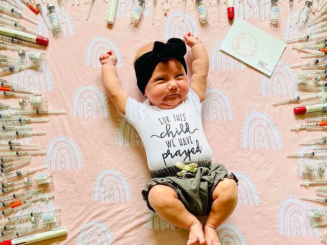 Arm, Facial Expression, Human Body, Happy, Pink, Font, Line, T-shirt, Smile, People, Toddler, Leisure, Pattern, Fun, Foot, Child, Shorts, Baby, Sitting, Person, Headwear