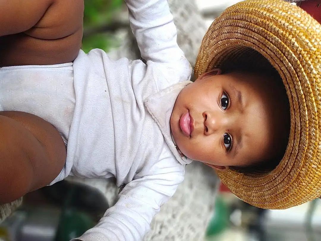 Skin, Head, Smile, Plant, Eyes, White, Tree, Hat, Happy, Gesture, Toddler, Child, People In Nature, Baby, Grass, Cap, Beauty, Sun Hat, Leisure, Knee, Person