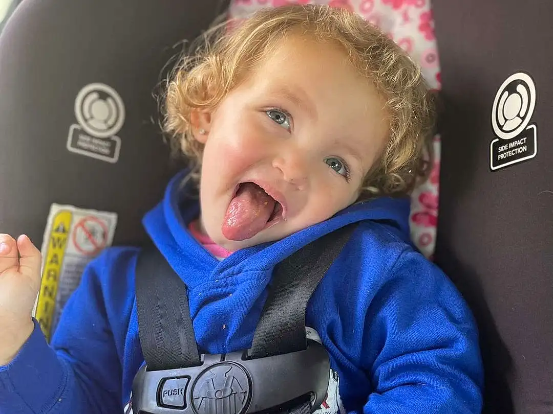 Smile, Seat Belt, Comfort, Baby In Car Seat, Sleeve, Happy, Baby Carriage, Toddler, Car Seat, Electric Blue, Personal Protective Equipment, Baby & Toddler Clothing, Baby, Steering Wheel, Auto Part, Child, Car Seat Cover, Fun, Baby Products, Travel, Person