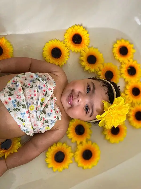 Smile, Flower, Head, Hairstyle, Eyes, Facial Expression, Plant, Happy, Yellow, Orange, Petal, Baby & Toddler Clothing, Toddler, Fun, Comfort, Child, Beauty, Pattern, Baby, Person, Joy, Headwear