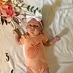 Skin, Comfort, Baby, Baby & Toddler Clothing, Pink, Finger, Smile, Toddler, Plant, Linens, Flower, Child, Pattern, Baby Sleeping, Petal, Baby Products, Rose, Peach, Room, Hair Accessory, Person, Headwear