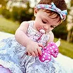Face, Photograph, Dress, Baby & Toddler Clothing, Sleeve, Happy, Pink, Toddler, Grass, Child, Headpiece, Baby, Fun, Pattern, Hair Accessory, Event, Fashion Accessory, Embellishment, Sitting, Petal, Person