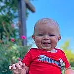 Smile, Skin, Hand, Sky, Eyes, Plant, People In Nature, Baby & Toddler Clothing, Happy, Gesture, Baby, Grass, Toddler, Leisure, Fun, T-shirt, Recreation, Sitting, Child, Laugh, Person, Joy