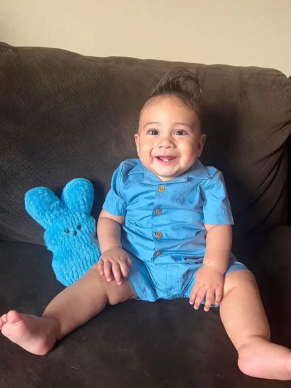 Face, Skin, Smile, Arm, Leg, Couch, Comfort, Sleeve, Baby & Toddler Clothing, Gesture, Finger, Flash Photography, Thigh, Lap, Happy, Electric Blue, Sock, Human Leg, Toddler, Foot, Person, Joy