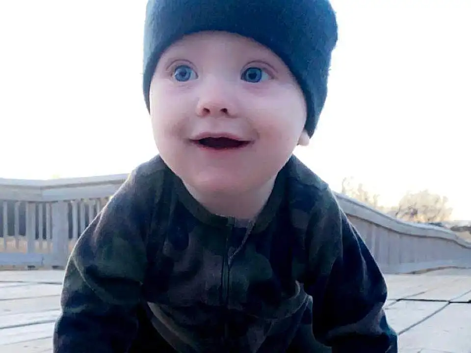 Face, Skin, Smile, Outerwear, Sky, Eyes, Baby & Toddler Clothing, Sleeve, Standing, Wood, Baby, Cap, Happy, Flash Photography, Toddler, People, Hardwood, Composite Material, Person, Joy, Headwear
