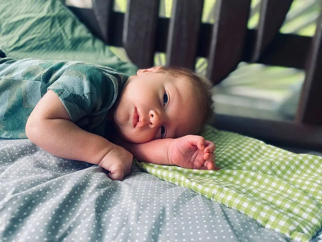 Skin, Head, Eyes, Eyebrow, Comfort, Textile, Flash Photography, Iris, Baby & Toddler Clothing, Grass, Baby, Toddler, Wood, Linens, Bedding, Room, Pattern, Child, Sitting