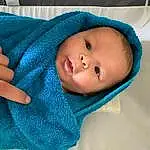 Nose, Face, Cheek, Skin, Head, Outerwear, Eyes, Eyebrow, Blue, Textile, Sleeve, Comfort, Iris, Gesture, Baby & Toddler Clothing, Baby, Aqua, Toddler, Electric Blue, Linens, Person