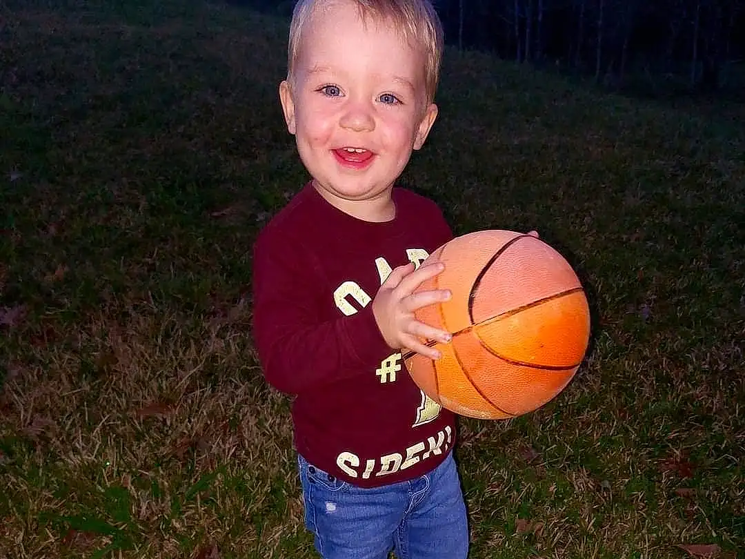 Smile, Basketball, Sports Equipment, People In Nature, Flash Photography, Ball, Gesture, Happy, Plant, Grass, Football, Tree, Sports Toy, Toddler, Fun, Child, T-shirt, Soccer Ball, Sitting, Play, Person, Joy