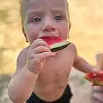 Clothing, Hand, Food, Jaw, Fruit, Natural Foods, People In Nature, Gesture, Finger, Happy, Thumb, Biting, Produce, Toddler, Grass, Nail, Local Food, Sweetness, Fun, Child, Person
