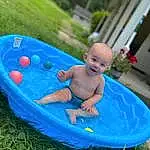 Azure, Smile, Baby Bathing, Grass, Leisure, Water, Plant, Toddler, Fun, Recreation, Baby, Baby & Toddler Clothing, Electric Blue, Child, Bathing, Event, Inflatable, Play, Vacation, Houseplant, Person