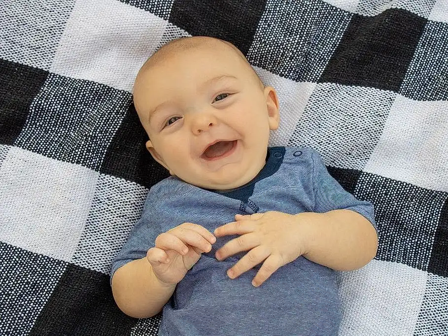 Smile, Skin, Comfort, Azure, Baby & Toddler Clothing, Sleeve, Textile, Baby, Linens, Toddler, Pattern, Happy, Child, Electric Blue, Plaid, Baby Products, Baby Laughing, Portrait Photography, Tartan, Person