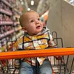 Clothing, Jeans, Orange, Shelf, Leisure, Fun, Toddler, Child, Sitting, Wood, T-shirt, Baby, Toy, Cart, Play, Portrait Photography, Room, Shopping Cart, Service, Baby Products, Person, Surprise