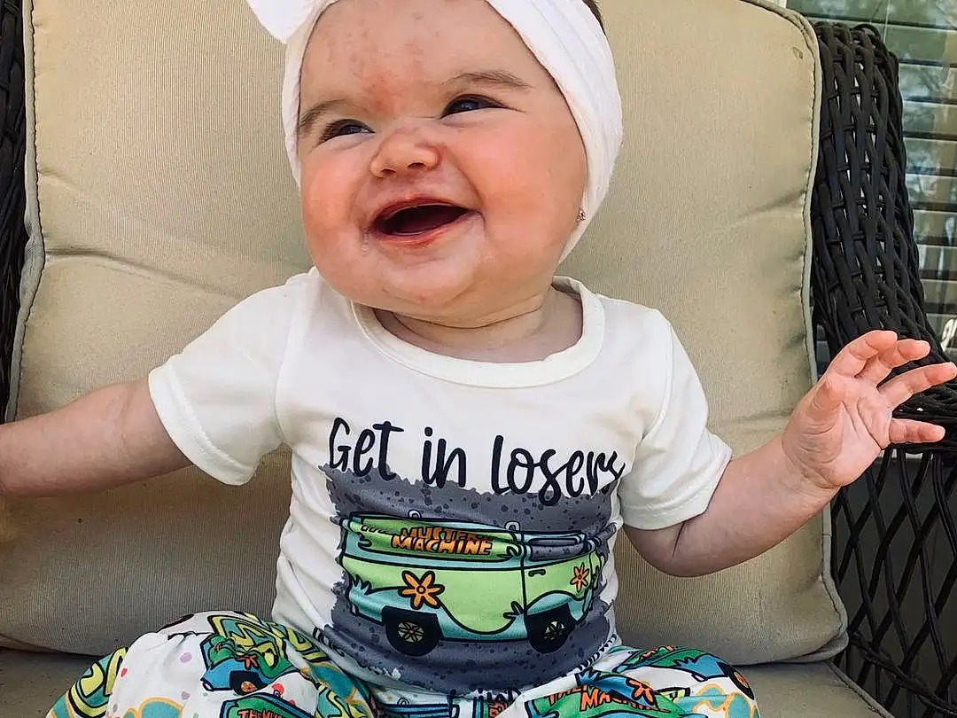 Clothing, Face, Smile, Skin, Head, Facial Expression, Baby & Toddler Clothing, Comfort, Sleeve, Baby, Happy, T-shirt, Baby Laughing, Cool, Toddler, Child, Sitting, Pattern, Thigh, Fun, Person, Joy, Headwear