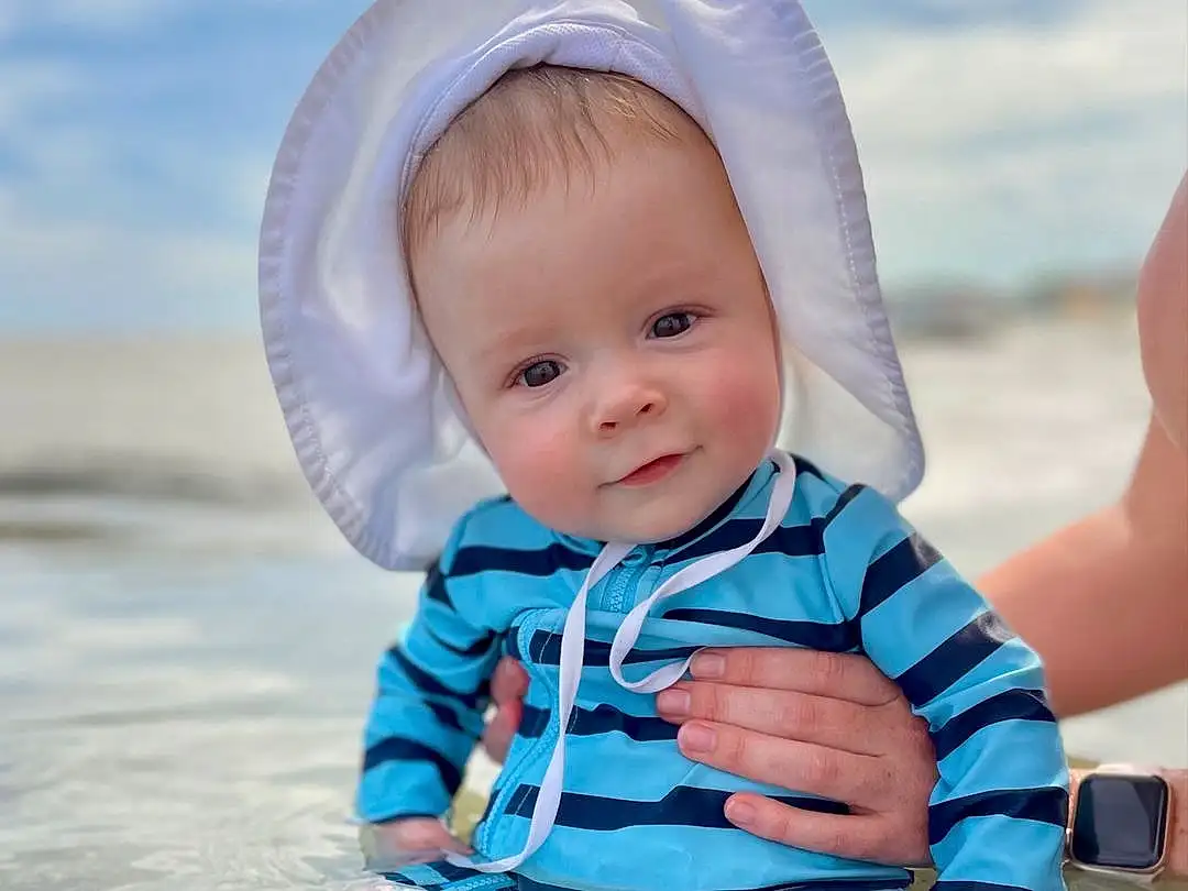 Skin, Water, Eyes, Azure, Baby & Toddler Clothing, Human Body, People In Nature, Sleeve, Happy, Standing, Smile, Body Of Water, Cap, Pink, Toddler, Fun, Leisure, Baby, Sky, Electric Blue, Person