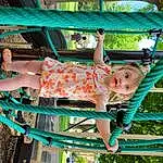 Facial Expression, Green, Smile, Shorts, Leisure, Woody Plant, Toddler, Tree, Fun, Recreation, Outdoor Furniture, Happy, Child, Baby & Toddler Clothing, Electric Blue, People In Nature, Sandal, Thigh, Spring, Grass, Person, Surprise
