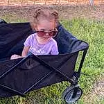 Tire, Plant, Sunglasses, Grass, Baby Carriage, Vehicle, Baby, Toddler, Wheel, People In Nature, Baby & Toddler Clothing, Comfort, Leisure, Goggles, Tree, Baby Products, Eyewear, Sitting, Fashion Accessory, Outdoor Furniture, Person